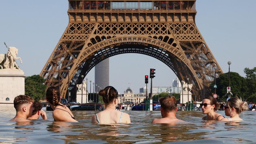 Orang-orang mendinginkan diri di Air Mancur Trocadero di sebelah Menara Eiffel saat suhu meningkat selama gelombang panas yang melanda sebagian besar negara, di Paris, Prancis, 22 Juni 2026. (REUTERS/Abdul Saboor)