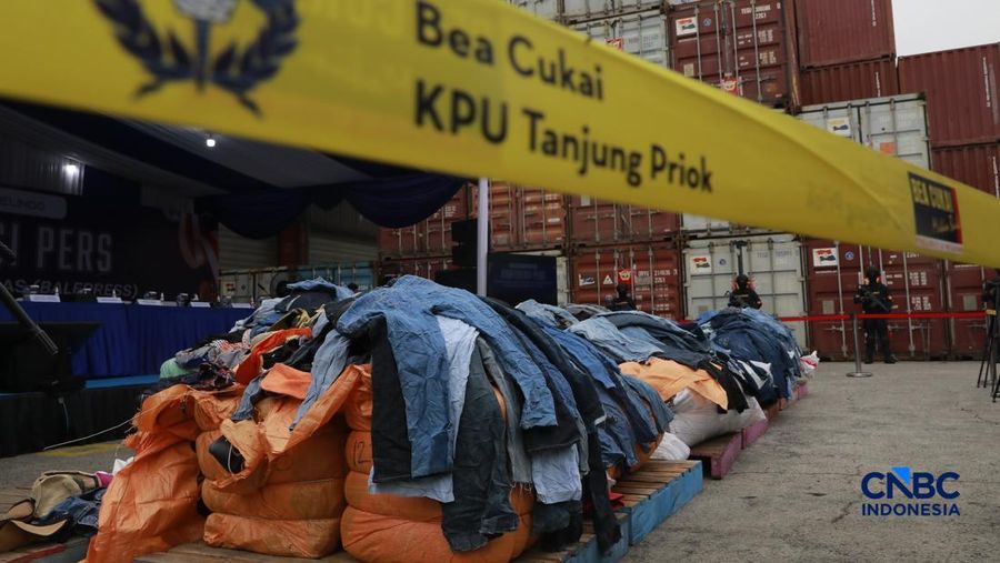 Sejumlah petugas bersenjata berjaga di depan kontainer saat Penindakan Bea Cukai Berupa Peti Kemas berisi pakaian bekas di Buffer Area TPS CDC Banda, Jalan Banda No.1, Tanjung Priok, Kota Jakarta Utara, Selasa, (23/6/2026). (CNBC Indonesia/Muhammad S