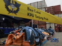 Sejumlah petugas bersenjata berjaga di depan kontainer saat Penindakan Bea Cukai Berupa Peti Kemas berisi pakaian bekas di Buffer Area TPS CDC Banda, Jalan Banda No.1, Tanjung Priok, Kota Jakarta Utara, Selasa, (23/6/2026). (CNBC Indonesia/Muhammad S
