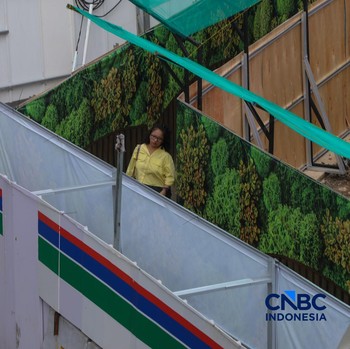 Warga berjalan kaki melewati trotoar darurat yang didekorasi menyerupai lorong taman labirin di atas kawasan proyek pengembangan kawasan Stasiun MRT Bundaran Hotel Indonesia, Jakarta, Rabu (24/6/2026). (CNBC Indonesia/Faisal Rahman)