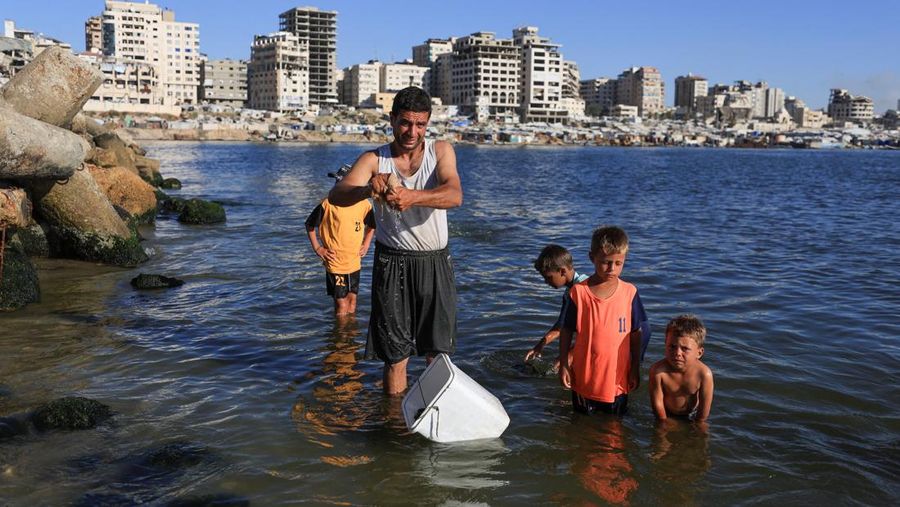 Warga Palestina memadati Pantai Kota Gaza pada Minggu (21/6/2026) untuk menyegarkan diri di tengah musim panas yang menyengat. (REUTERS/DAWOUD ABU ALKAS)