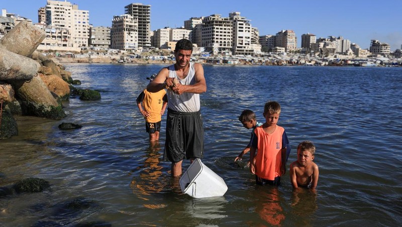 Warga Palestina memadati Pantai Kota Gaza pada Minggu (21/6/2026) untuk menyegarkan diri di tengah musim panas yang menyengat. (REUTERS/DAWOUD ABU ALKAS)