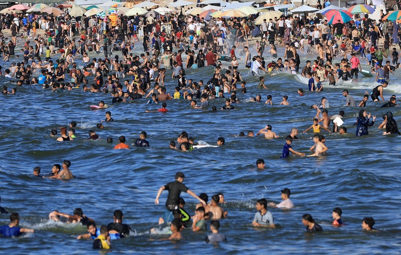 Warga Palestina memadati Pantai Kota Gaza pada Minggu (21/6/2026) untuk menyegarkan diri di tengah musim panas yang menyengat. (REUTERS/DAWOUD ABU ALKAS)