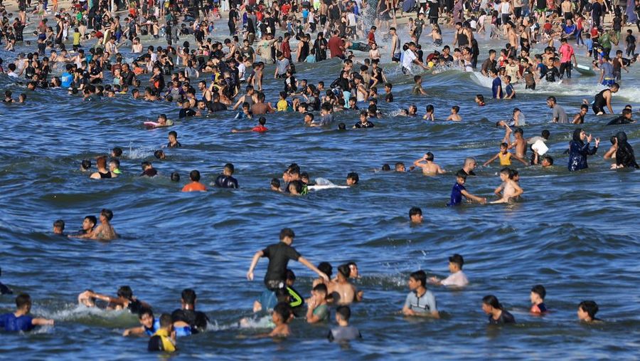 Warga Palestina memadati Pantai Kota Gaza pada Minggu (21/6/2026) untuk menyegarkan diri di tengah musim panas yang menyengat. (REUTERS/DAWOUD ABU ALKAS)