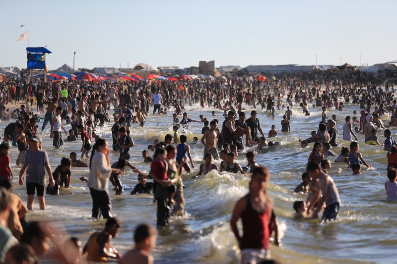 Warga Palestina memadati Pantai Kota Gaza pada Minggu (21/6/2026) untuk menyegarkan diri di tengah musim panas yang menyengat. (REUTERS/DAWOUD ABU ALKAS)