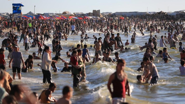 Warga Palestina memadati Pantai Kota Gaza pada Minggu (21/6/2026) untuk menyegarkan diri di tengah musim panas yang menyengat. (REUTERS/DAWOUD ABU ALKAS)