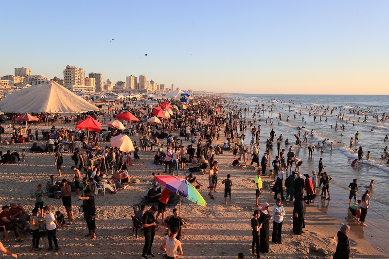 Warga Palestina memadati Pantai Kota Gaza pada Minggu (21/6/2026) untuk menyegarkan diri di tengah musim panas yang menyengat. (REUTERS/DAWOUD ABU ALKAS)