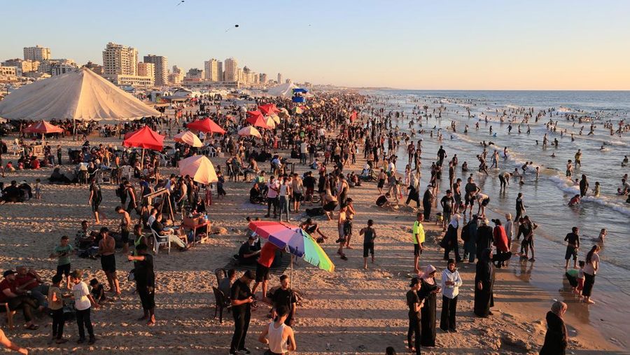 Warga Palestina memadati Pantai Kota Gaza pada Minggu (21/6/2026) untuk menyegarkan diri di tengah musim panas yang menyengat. (REUTERS/DAWOUD ABU ALKAS)