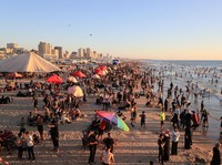 Warga Palestina memadati Pantai Kota Gaza pada Minggu (21/6/2026) untuk menyegarkan diri di tengah musim panas yang menyengat. (REUTERS/DAWOUD ABU ALKAS)