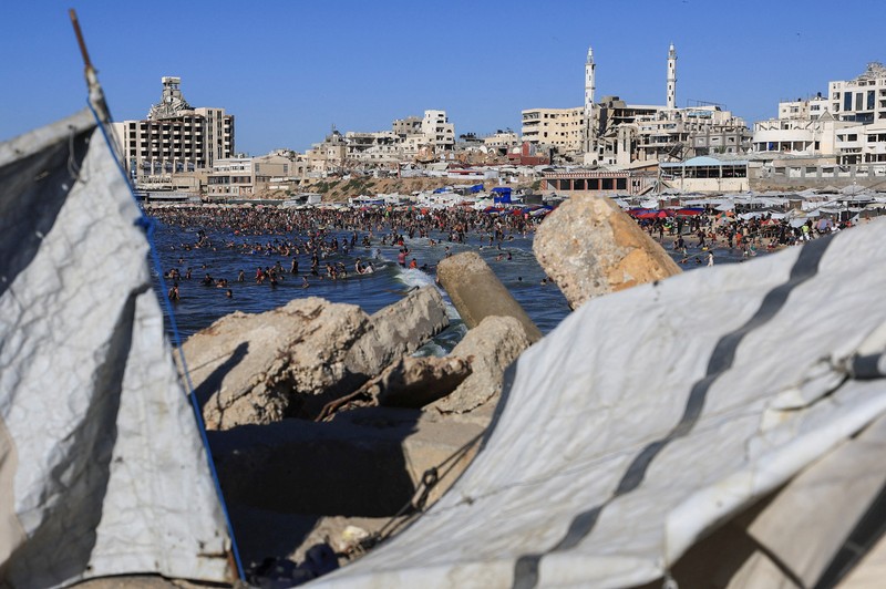 Warga Palestina memadati Pantai Kota Gaza pada Minggu (21/6/2026) untuk menyegarkan diri di tengah musim panas yang menyengat. (REUTERS/DAWOUD ABU ALKAS)