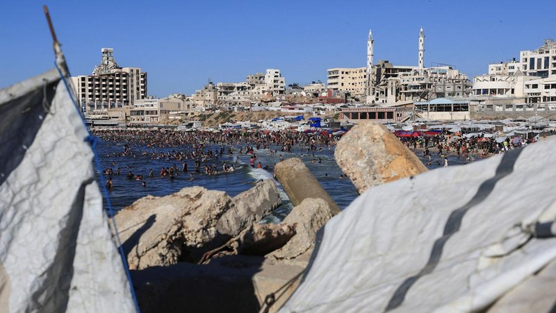 Warga Palestina memadati Pantai Kota Gaza pada Minggu (21/6/2026) untuk menyegarkan diri di tengah musim panas yang menyengat. (REUTERS/DAWOUD ABU ALKAS)