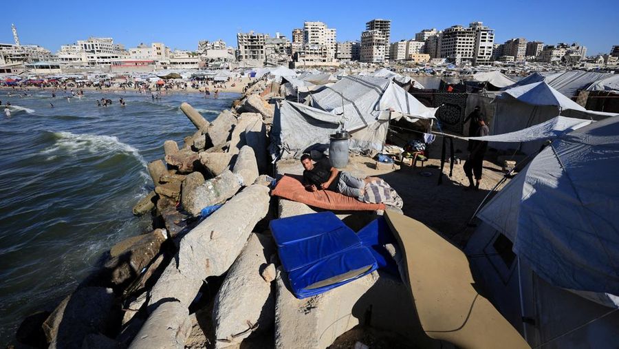 Warga Palestina memadati Pantai Kota Gaza pada Minggu (21/6/2026) untuk menyegarkan diri di tengah musim panas yang menyengat. (REUTERS/DAWOUD ABU ALKAS)