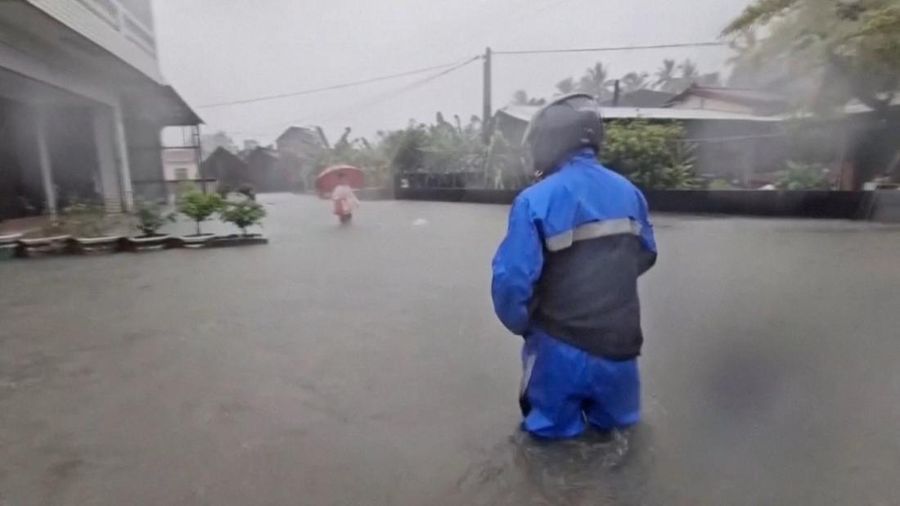 Orang-orang berdiri di tengah air banjir saat hujan deras akibat lewatnya topan Mekkhala di dekatnya, nan sedang menuju Jepang, di Pingtung, Taiwan, 25 Juni 2026, dalam cuplikan layar nan diambil dari sebuah video.