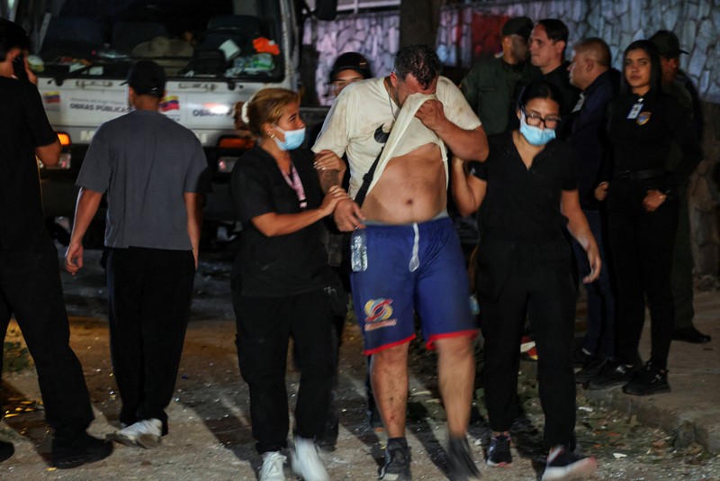 Fanny Nasri menunggu di lokasi bangunan yang runtuh sementara petugas penyelamat mencari putranya, Antonio Nasri, bersama Noemi Cordoba, yang menunggu kabar tentang cucunya, setelah gempa bumi di Caracas, Venezuela, 25 Juni 2026. (REUTERS/Gaby Oraa)
