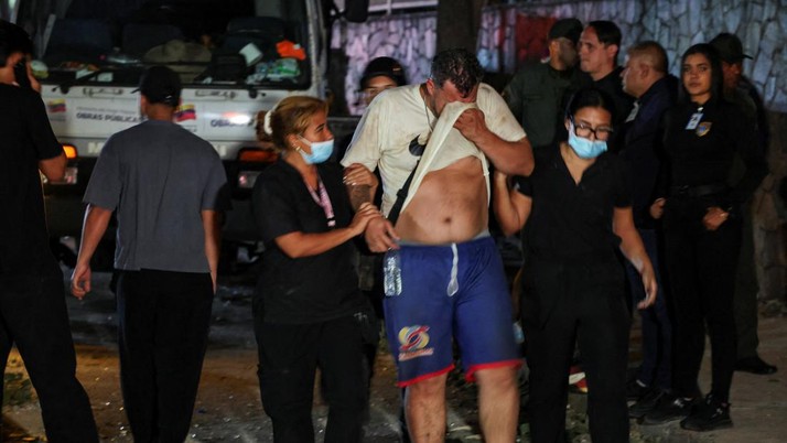 Petugas darurat membantu seorang pria di lokasi bangunan yang runtuh setelah gempa bumi di Caracas, Venezuela, 24 Juni 2026. (REUTERS/Leonardo Fernandez Viloria)