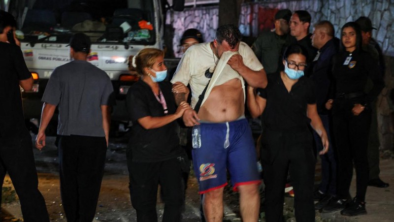 Petugas darurat membantu seorang pria di lokasi bangunan yang runtuh setelah gempa bumi di Caracas, Venezuela, 24 Juni 2026.