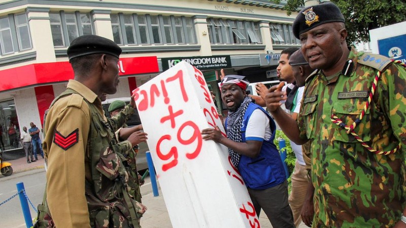 Seorang demonstran membawa peti mati tiruan sementara polisi bereaksi selama demonstrasi untuk memperingati ulang tahun kedua protes anti-pemerintah yang mematikan pada tahun 2024, di Mombasa, Kenya, 25 Juni 2026.