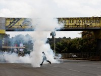 Seorang pria berlari menerobos gas air mata yang digunakan polisi untuk membubarkan demonstran selama demonstrasi untuk memperingati ulang tahun kedua protes anti-pemerintah yang mematikan pada tahun 2024, di Nairobi, Kenya, 25 Juni 2026. (REUTERS/Mo