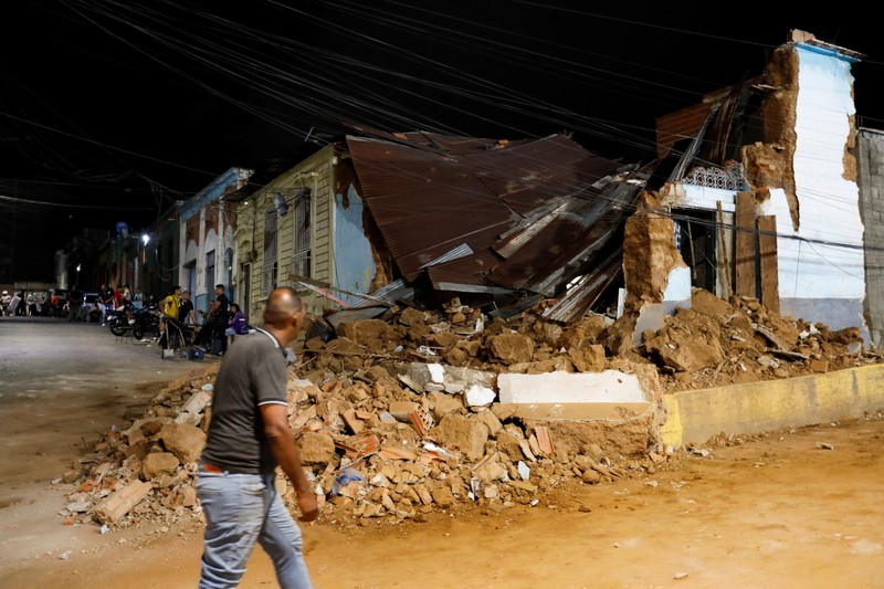 Fanny Nasri menunggu di lokasi bangunan yang runtuh sementara petugas penyelamat mencari putranya, Antonio Nasri, bersama Noemi Cordoba, yang menunggu kabar tentang cucunya, setelah gempa bumi di Caracas, Venezuela, 25 Juni 2026. (REUTERS/Gaby Oraa)