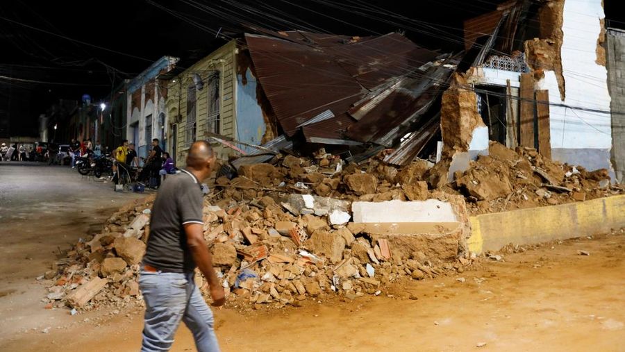 Seseorang berjalan melewati bangunan yang rusak akibat gempa bumi, di Caracas, Venezuela, 24 Juni 2026.