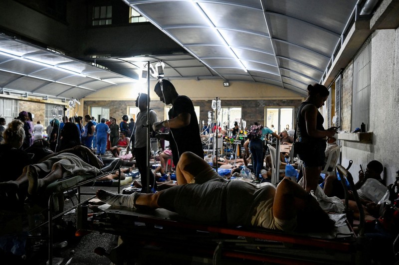 Fanny Nasri menunggu di lokasi bangunan yang runtuh sementara petugas penyelamat mencari putranya, Antonio Nasri, bersama Noemi Cordoba, yang menunggu kabar tentang cucunya, setelah gempa bumi di Caracas, Venezuela, 25 Juni 2026. (REUTERS/Gaby Oraa)