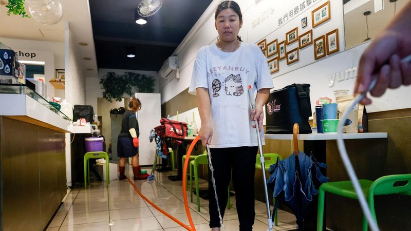 Pemilik restoran dan staf membersihkan toko mereka yang terendam banjir setelah hujan lebat yang dibawa oleh Badai Tropis Mekkhala menyebabkan banjir di Hsinchu, Taiwan, 26 Juni 2026.