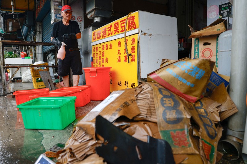 Warga membersihkan lumpur dan puing-puing dari daerah yang tergenang banjir setelah hujan deras akibat Badai Tropis Mekkhala di Hsinchu, Taiwan, 26 Juni 2026. (REUTERS/Ann Wang)