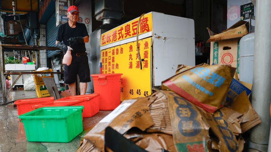 Seorang pemilik restoran membersihkan toko yang terendam banjir setelah hujan deras akibat Badai Tropis Mekkhala menyebabkan banjir di Hsinchu, Taiwan, 26 Juni 2026.