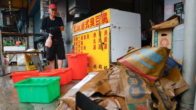 Seorang pemilik restoran membersihkan toko yang terendam banjir setelah hujan deras akibat Badai Tropis Mekkhala menyebabkan banjir di Hsinchu, Taiwan, 26 Juni 2026.
