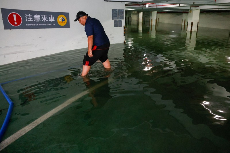 Warga membersihkan lumpur dan puing-puing dari daerah yang tergenang banjir setelah hujan deras akibat Badai Tropis Mekkhala di Hsinchu, Taiwan, 26 Juni 2026. (REUTERS/Ann Wang)