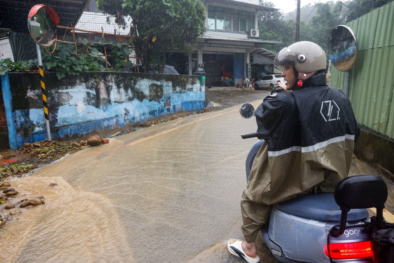 Warga membersihkan lumpur dan puing-puing dari daerah yang tergenang banjir setelah hujan deras akibat Badai Tropis Mekkhala di Hsinchu, Taiwan, 26 Juni 2026. (REUTERS/Ann Wang)