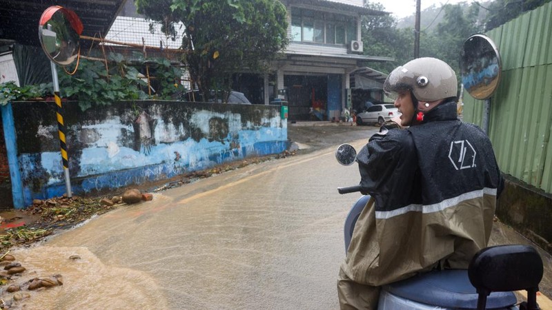 Seseorang yang mengendarai skuter menunggu di pinggir jalan yang tergenang air setelah hujan deras akibat Badai Tropis Mekkhala menyebabkan banjir di Hsinchu, Taiwan, 26 Juni 2026.