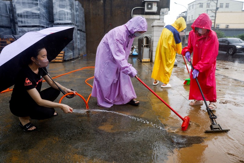 Warga membersihkan lumpur dan puing-puing dari daerah yang tergenang banjir setelah hujan deras akibat Badai Tropis Mekkhala di Hsinchu, Taiwan, 26 Juni 2026. (REUTERS/Ann Wang)