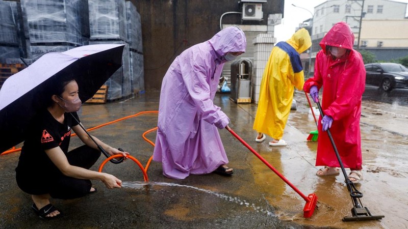 Warga membersihkan lumpur dan puing-puing dari daerah yang tergenang banjir setelah hujan deras akibat Badai Tropis Mekkhala di Hsinchu, Taiwan, 26 Juni 2026. (REUTERS/Ann Wang)