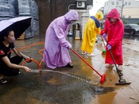 Warga membersihkan lumpur dan puing-puing dari daerah yang tergenang banjir setelah hujan deras akibat Badai Tropis Mekkhala di Hsinchu, Taiwan, 26 Juni 2026. (REUTERS/Ann Wang)