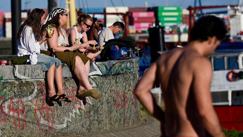 Orang-orang menikmati berjemur di pelabuhan Hamburg, Jerman, 26 Juni 2026. (REUTERS/Fabian Bimmer)