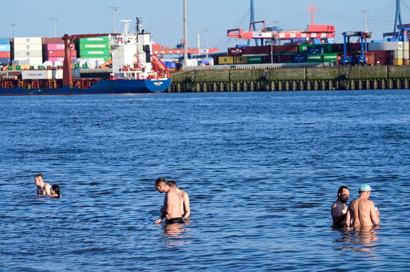 Orang-orang menggunakan payung dan kipas angin untuk melindungi diri dari suhu tinggi di Munich, Jerman, 26 Juni 2026. (REUTERS/Angelika Warmuth)