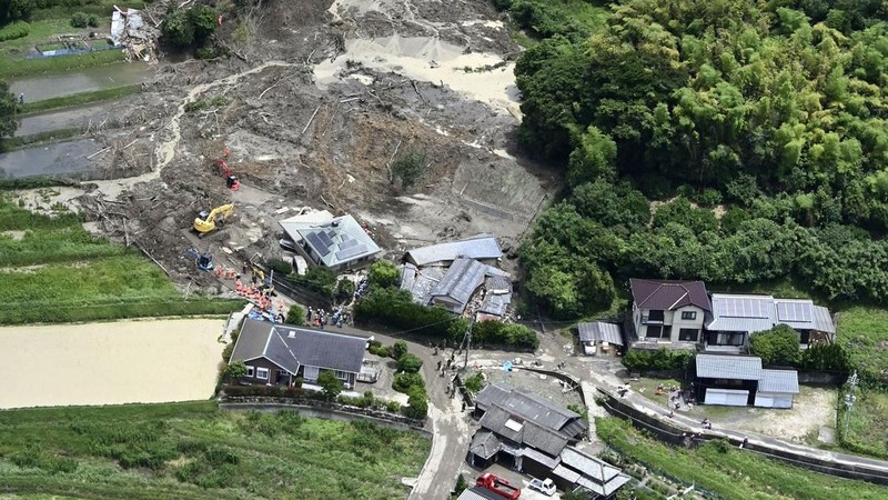 Petugas polisi dan tim penyelamat melakukan operasi pencarian dan penyelamatan di sebuah rumah yang tertimbun tanah longsor akibat hujan lebat di Hirao, Prefektur Yamaguchi, Jepang, Sabtu (27/6/2026). (Kyodo/via REUTERS)