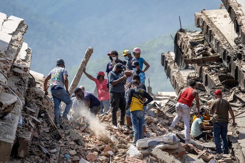 Orang-orang berkumpul saat petugas penyelamat membantu upaya penyelamatan setelah gempa bumi melanda negara itu, di La Guaira, Venezuela, 27 Juni 2026. (REUTERS/Maxwell Briceno)