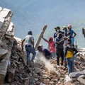 Para sukarelawan dan warga mencari korban selamat di reruntuhan bangunan yang runtuh di Caraballeda, negara bagian La Guaira, Venezuela, pada 28 Juni 2026, setelah gempa bumi. (MIGUEL MEDINA/Pool via REUTERS)