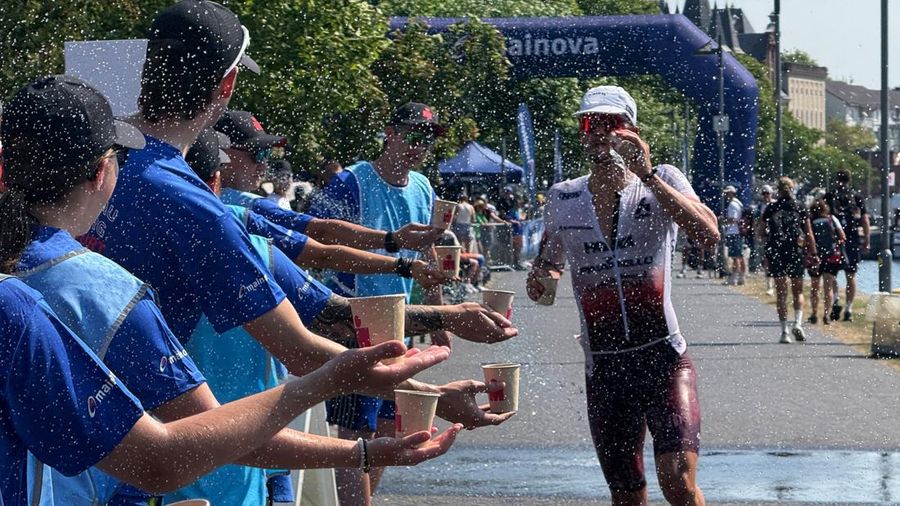Para sukarelawan menawarkan minuman kepada seorang atlet Ironman selama gelombang panas yang sedang berlangsung di Frankfurt, Jerman, 28 Juni 2026.