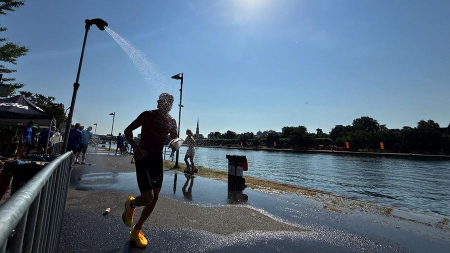 Seorang atlet Ironman berlari melewati pancuran di dekat Sungai Main untuk mendinginkan diri selama gelombang panas yang sedang berlangsung di Frankfurt, Jerman, 28 Juni 2026.