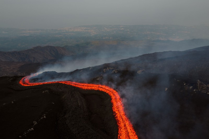 Aliran lava cair yang mengalir menuruni lereng Gunung Etna selama letusan, di Pulau Sisilia, Italia, Senin (29/6/2026). (REUTERS/Giuseppe Di Stefano)