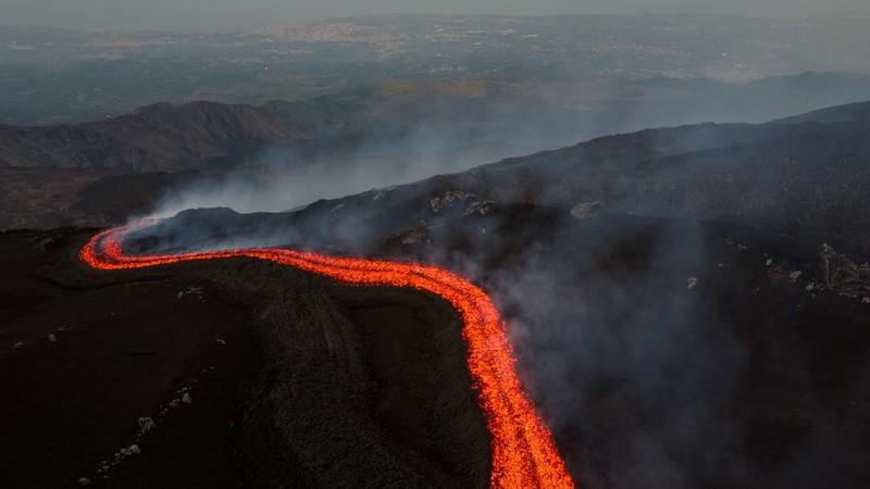 Aliran lava cair yang mengalir menuruni lereng Gunung Etna selama letusan, di Pulau Sisilia, Italia, Senin (29/6/2026). (REUTERS/Giuseppe Di Stefano)