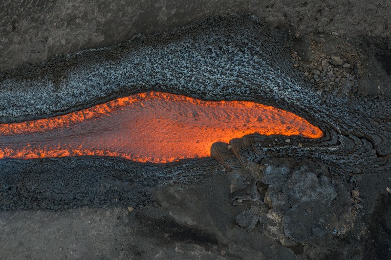 Aliran lava cair yang mengalir menuruni lereng Gunung Etna selama letusan, di Pulau Sisilia, Italia, Senin (29/6/2026). (REUTERS/Giuseppe Di Stefano)