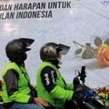 Pengemudi ojek online melintas di depan karangan bunga "Doa dan Harapan untuk Keadilan Indonesia" jelang sidang putusan terdakwa kasus dugaan korupsi pengadaan Chromebook dan Chrome Device Management (CDM) dalam program digitalisasi pendidikan di Kem