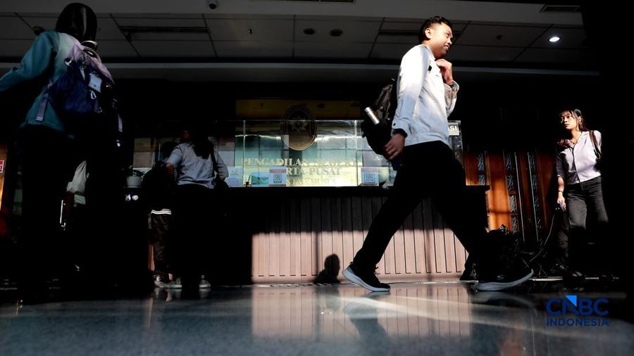 Pengemudi ojek online melintas di depan karangan bunga