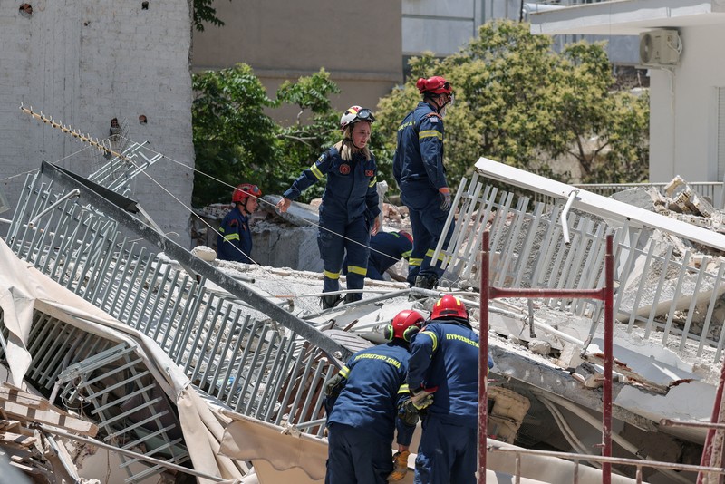 Petugas darurat bekerja pada lokasi runtuhnya bangunan apartemen di lingkungan Petralona, ​​Athena, Yunani, Selasa (30/6/2026). (REUTERS/Louisa Gouliamaki)