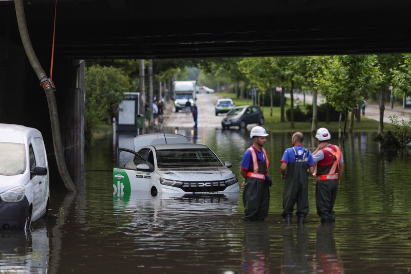 Para pekerja menyaksikan air hujan dipompa keluar dari terowongan kereta api yang tergenang banjir di bagian utara Bukares, Rumania, 1 Juli 2026. (Inquam Photos/Octav Ganea via REUTERS)