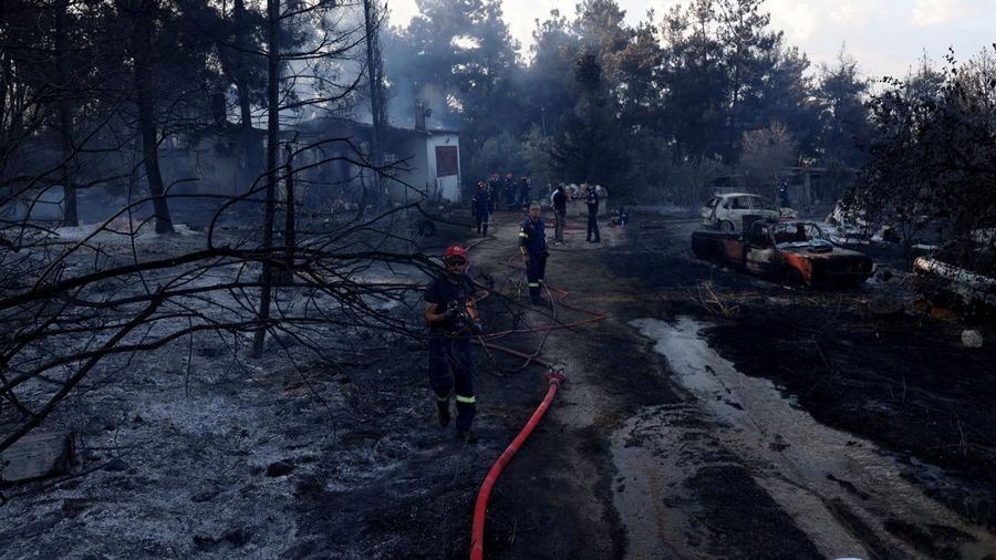 Petugas pemadam kebakaran berupaya memadamkan kebakaran hutan di dekat sebuah rumah yang terbakar di dekat desa Liti, Thessaloniki, Yunani, 30 Juni 2026.